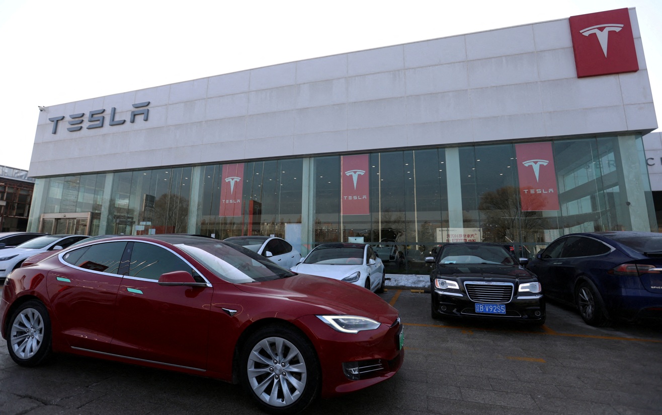 Um carro Tesla passa por uma loja da fabricante de veículos elétricos em Pequim, China