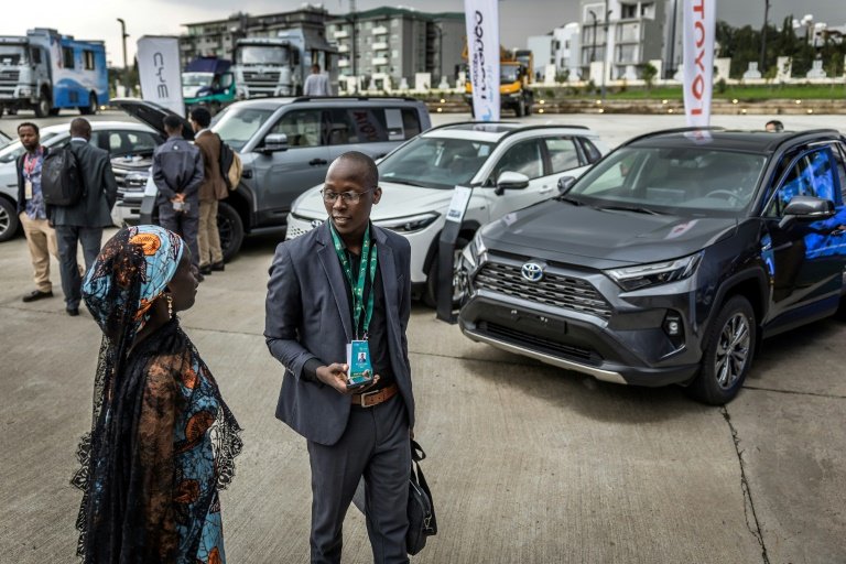 Delegados e participantes reúnem-se para avaliar os veículos elétricos expostos durante a segunda Cúpula Africana sobre o Clima em Adis Abeba, Etiópia, em 8 de setembro de 2025 - AFP
