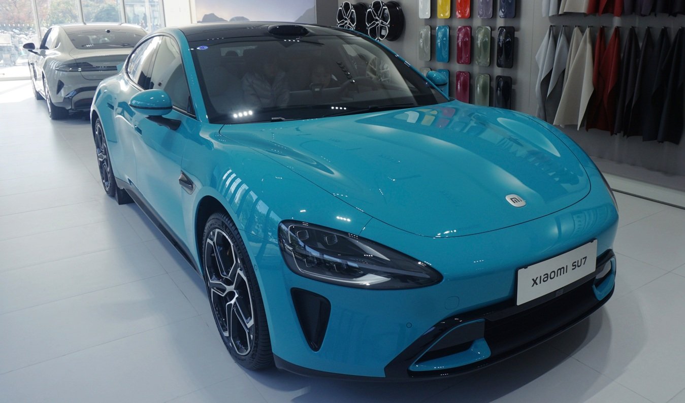 Pessoas conferem um sedã elétrico Xiaomi SU7 em uma loja da Xiaomi em Hangzhou, na província de Zhejiang, no leste da China, na quarta-feira, 1º de janeiro de 2025. A novata chinesa no setor automobilístico entregou 135.000 carros em 2024